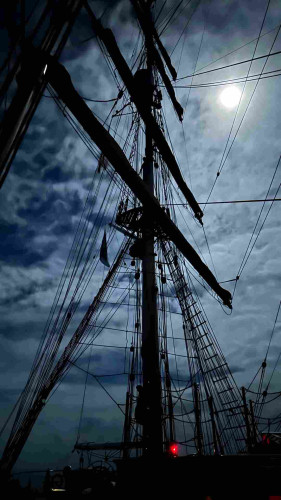 Moon lit mizzen mast with all of the square sails lashed to their yards. 