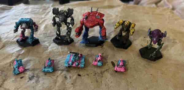 Five Battletech miniatures 

Adder in pink and blue
Timber Wolf in gray with white and black stripes
King Crab in red with blue legs 
Owl with brown body, yellow head and arms
Raven with purple body and green limbs 

Five Ogre tank miniatures
Four light tanks in pink and blue
One mobile howitzer in pink and blue