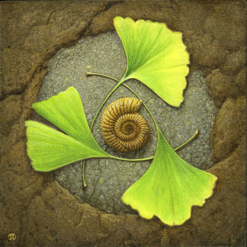 The spiral of an ammonite fossil sits inside a triangle formed by three interlocking ginkgo leaves that pop vibrant green and yellow against earth tones. The fossil rests in a circle of grey stone with  the leaves slightly overlapping the natural brown stone that surround it.
