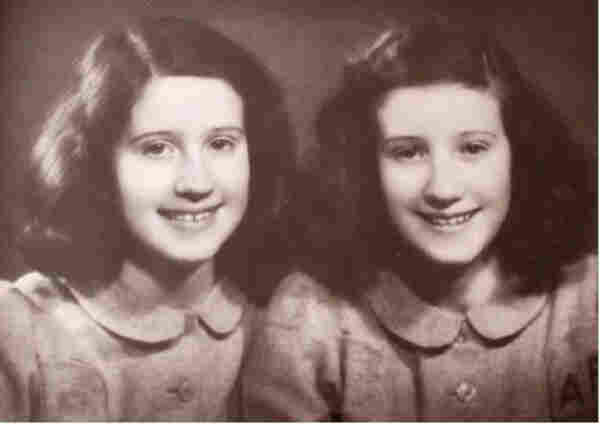Portrait photo of two sisters next to each other. Both are smiling and both have similar long hair reaching her shoulders. 