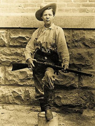 Pearl Hart attired in men's clothing, in a cowboy hat, suspenders, and carrying a gun. By Unknown photographer - Historian Insight, Public Domain, https://commons.wikimedia.org/w/index.php?curid=54702610