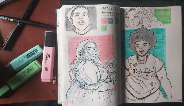 a photo of a sketchbook and some markers. The sketchbook has 4 portraits of beautiful big black women 