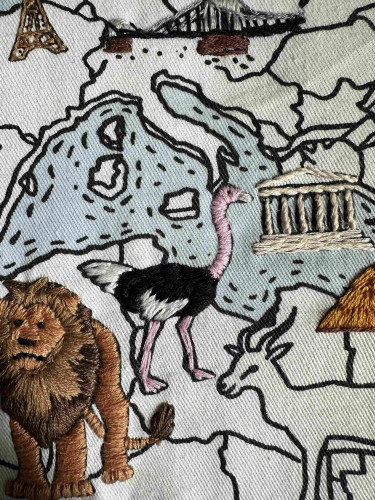 An embroidered ostrich. It’s on a fabric map. And embroidered lion is also visible 