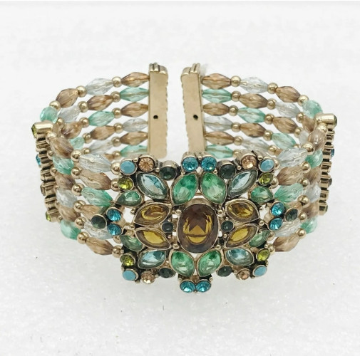 A cuff bracelet with five rows of jeweled beads on a metal wire frame in silver, green, blue, amber and turquoise. Front on