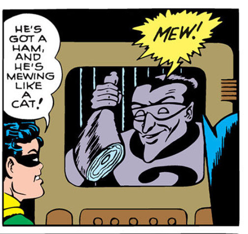A Batman comic with Riddler in a paddy wagon trying to get Batman and Robin to guess a riddle. He's holding a ham and mewing like a cat. Robin is saying: He's got a ham and he's mewing like a cat!