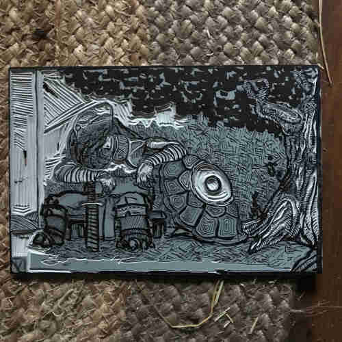 Linogravure en cours : un guerrier tortue se repose sous un olivier. Il s’appuie sur un bouclier-carapace doté d’un œil 