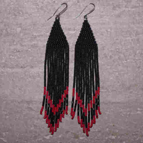Black and red Native beaded earrings on a stone background