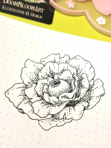 Dotted notebook with a drawing of a rose with an eyeball in its center, made with linkes and dots.