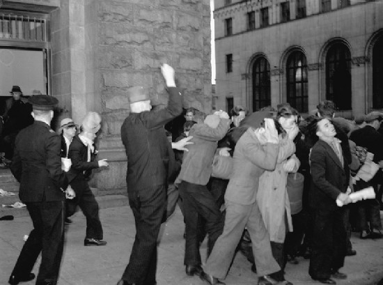 A plainclothes Mountie clubbing protesters leaving the post office. By Province Newspaper - http://www3.vpl.vancouver.bc.ca/spe/histphotos/histPhotoAdvancedSearch.html, Public Domain, https://commons.wikimedia.org/w/index.php?curid=1432229