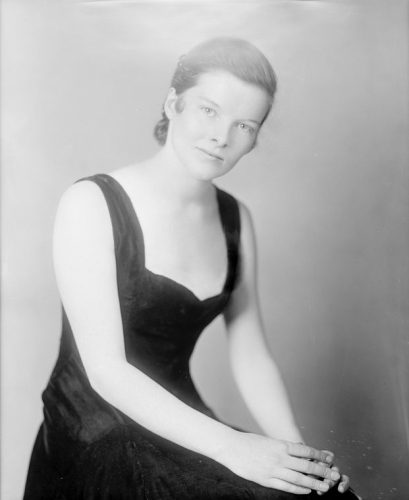 A posed portrait of a young woman with short hair.