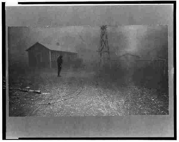  The image depicts a scene of a dust storm in New Mexico during the spring of 1935. A solitary figure stands near the center of the frame, appearing as if they are being swallowed by the storm. The person is dwarfed by the cloud of dust that envelopes them, their form nearly obscured from view due to the intensity of the storm.

In the background, a dilapidated house can be seen, hinting at the hardships faced by those living in such harsh conditions. The sky above is dark and heavy with clouds, suggesting an impending or ongoing severe weather event.

The ground appears to be strewn with debris, indicating that the storm is not just a dust cloud but also brings destruction in its wake. There are no visible trees or greenery, further emphasizing the desolate nature of the scene.

The image captures a moment of intense weather, likely part of the Dust Bowl era, which was marked by severe droughts and stormy conditions that caused significant displacement and hardships for farmers and families in this region.