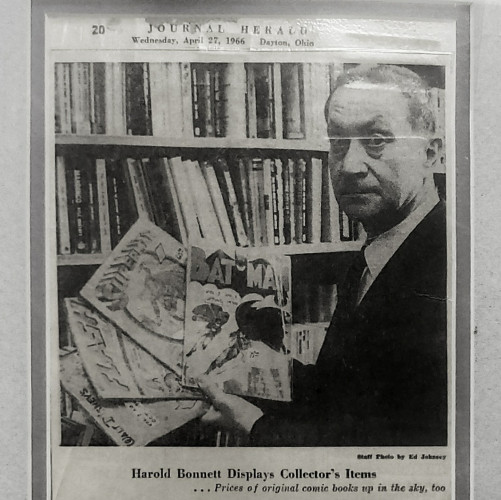 From page 20 of the JOURNAL HERALD, Wednesday, April 27, 1966 in Dayton, Ohio; Staff Photo by Ed Johnsey.
"Harold Bonnett Displays Collector's Items.
... Prices of original comic books up in the sky, too."
A black and white photo of my grandfather in front of a rack of paperbacks in our family shop, Bonnett's Bookstore. He's holding four old comics fanned out. The comics are: BAT MAN № 1, SUPERMAN № 1, FLASH COMICS № 1, & WALT DISNEY COMICS and Stories № 1.