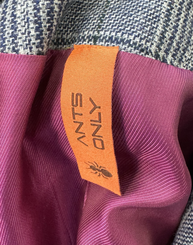 An orange tag in my jacket that says “Ants Only” with a simple ant logo as if this were some real brand. 
