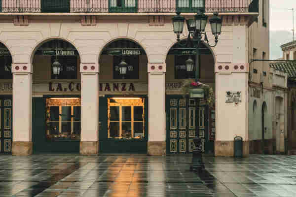 Fotografía donde se ve parte de la plaza Luis López Allué (Huesca) y al fondo la tienda de La Confianza. La tienda de ultramarinos más antigua y en activo de España.