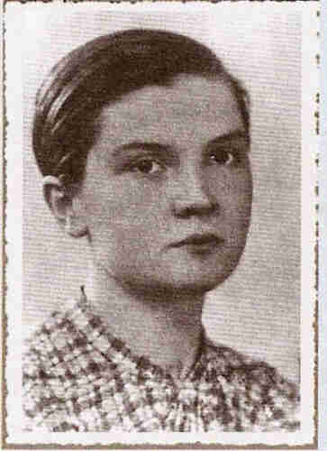 Portrait photo of a young girl in checked blouse. She has her hair bombed on the right. Neutral expression.