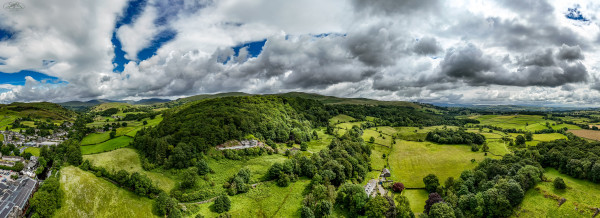 Panoramic shots over Staveley near Kendal in Cumbria UK with green fields and woodland in views around the town