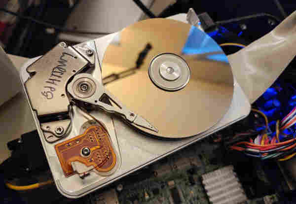 An old spinning-rust IDE hard drive. The case is open, so you can see the head and the platters.

It's spinning. 