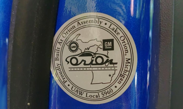 Sticker on automobile door, identifying vehicle as assembled by union labor.