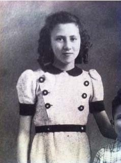 Black and white photograph of a young gril standing, wearing a vintage dress with short sleeves,