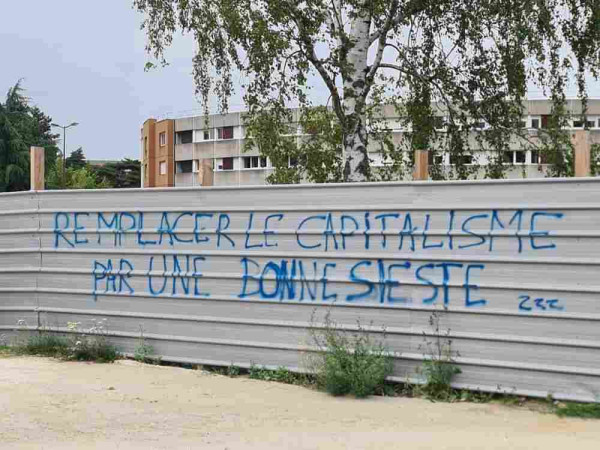 "Replace capitalism with a good nap" written on a fence in French