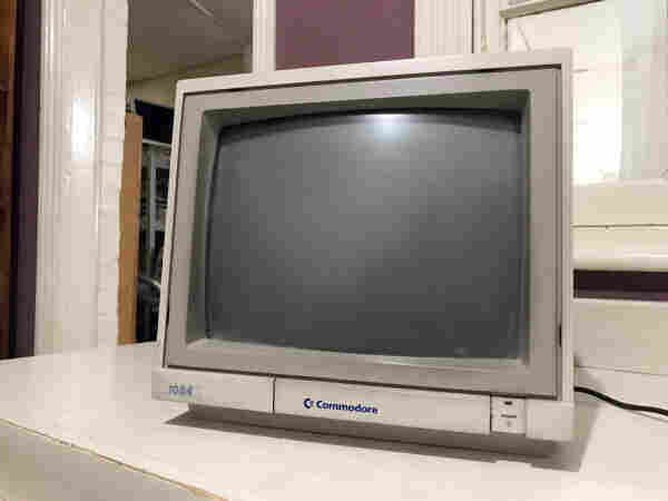 A photo of a dirty commodore 1084 monitor. It looks like a well used piece of old equipment, with grubby fingermarks after being moved about for years by workers.