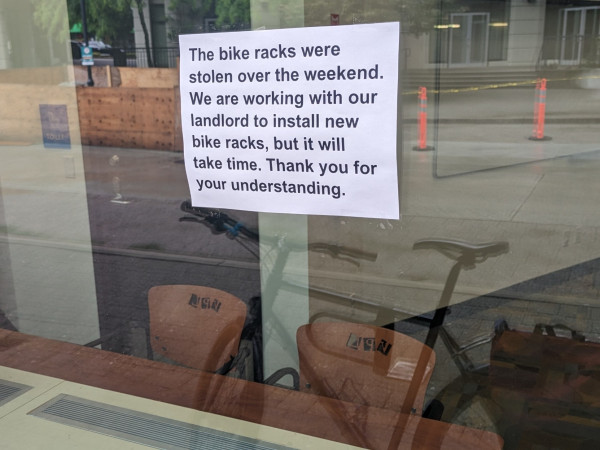 Sign at a Vancouver public library branch that reads: "The bike racks were stolen over the weekend. We are working with our landlord to install new racks, but it will take time. Thank you for your understanding."