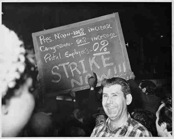 Postal workers on the picket line. Sign reads “President Nixon: 100% increase; Congressmen: 50% increase; Postal Employees: 0%. STRIKE NOW!”