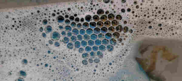 Soap suds in a prounced honeycomb pattern with a vaguely heartlike shape