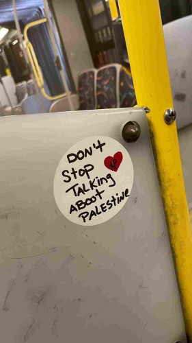 Sticker in a bus that says "Don't stop talking about Palestine"