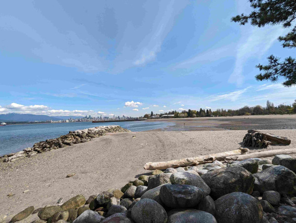 Photo of a large ocean beach with the City Vancouver in the background.