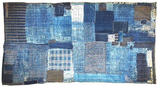 A late 19th Century Japanese boro-style child's sleeping mat composed of several layers of indigo dyed cotton fabrics, patched and heavily stitched.