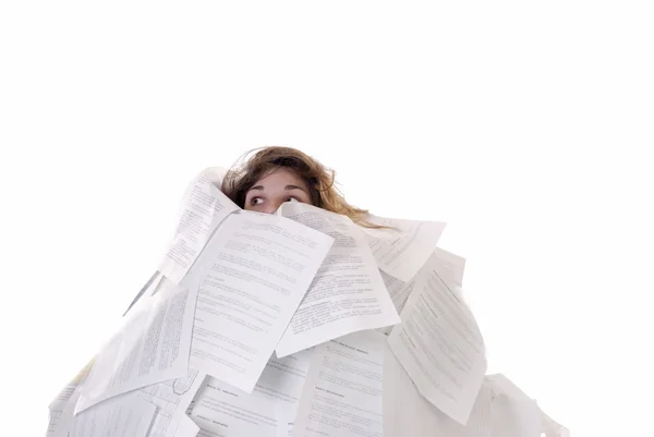 Photo of a person with long brownish hair buried in sheets of paper with text printed on them.