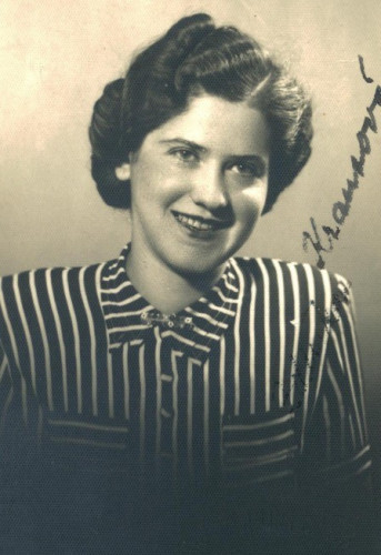 Vintage black and white portrait of a smiling woman with curled hair, wearing a striped blouse. The handwritten name on the image is visible.
