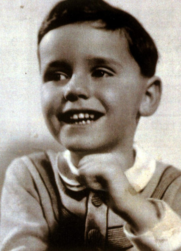 Black and white photo of a young boy smiling.