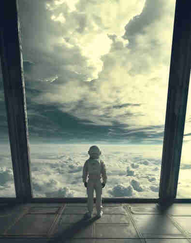 Astronaut standing at the large window of a space station, overlooking a vast cloudscape.