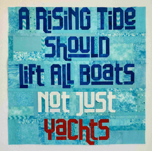 Scrappy pieced letters that read “A rising tide should lift all boats not just yachts” laid out in rows on a square teal background. The first letters are in blue, not just is in white and yachts is in red 