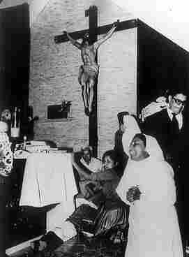 Photo that appeared in El País on 7 November 2009 with the information that the state of El Salvador recognized its responsibility in the crime. Shows Romero’s body on the floor of a church, below a statue of Jesus, with crying nuns and others standing by his side. By http://www.elpais.com/fotografia/Oscar/Arnulfo/Romero/asesinado/disparo/pecho/elpdiaint/20091107elpepuint_6/Ies/, Fair use, https://en.wikipedia.org/w/index.php?curid=24996519