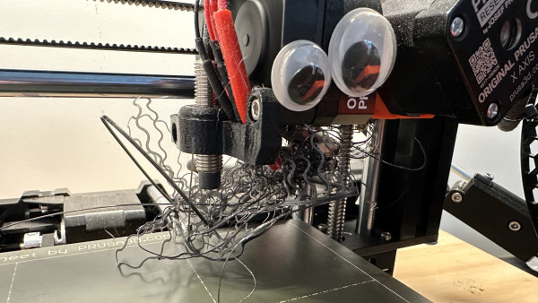3D printer with a mess of filament stuck to the extruder