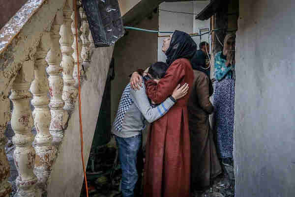A woman in a headscarf embracing a young boy in a distressed building environment, with other individuals in the background observing.

Palestinians inspect their destroyed house after an Israeli airstrike in Rafah, southern Gaza Strip, February 8, 2024. 

(Abed Rahim Khatib/Flash90)