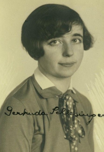 Vintage portrait of a woman with short, wavy hair, wearing a blouse and a patterned tie. 