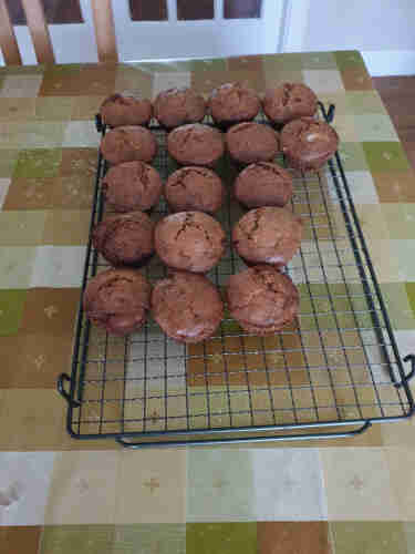 A batch of light brown muffins on a cooling rack. You can't really tell but they have mince pie filling inside.
