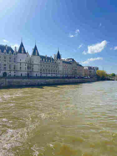 A view over the Seine in Paris, looking at the grand Conciergerie  museum which is built in pale stone with turrets! 