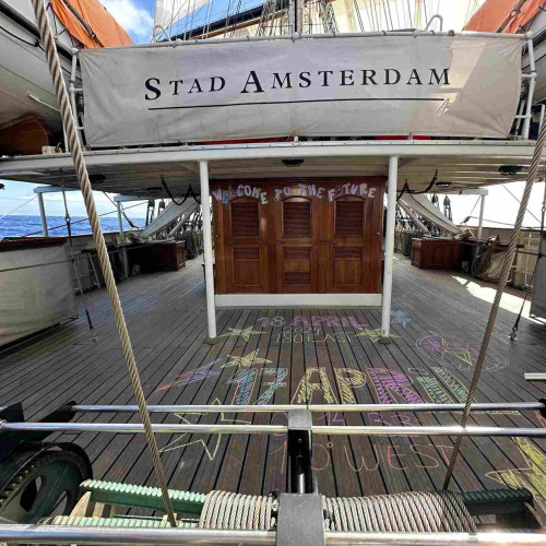 Ship deck painted with the words 18 April and 17 April indicating the date line. A sign on the deckhouse says Welcome to the Future. 